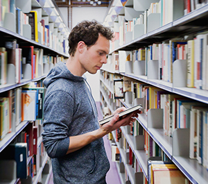 college student reads at library