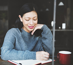 Girl at coffee shop makes plan for paying off holiday debt