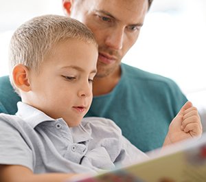 Father and young son read a book