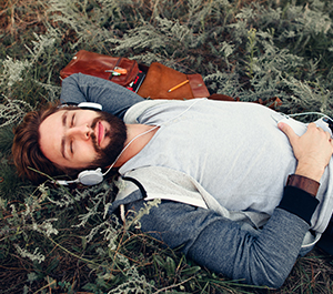 Man rests in park listening to music