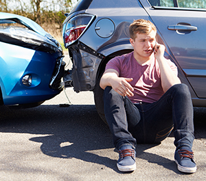 Young man makes phone call after car accident