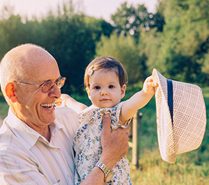 Grandfather holds granddaughter on a walk